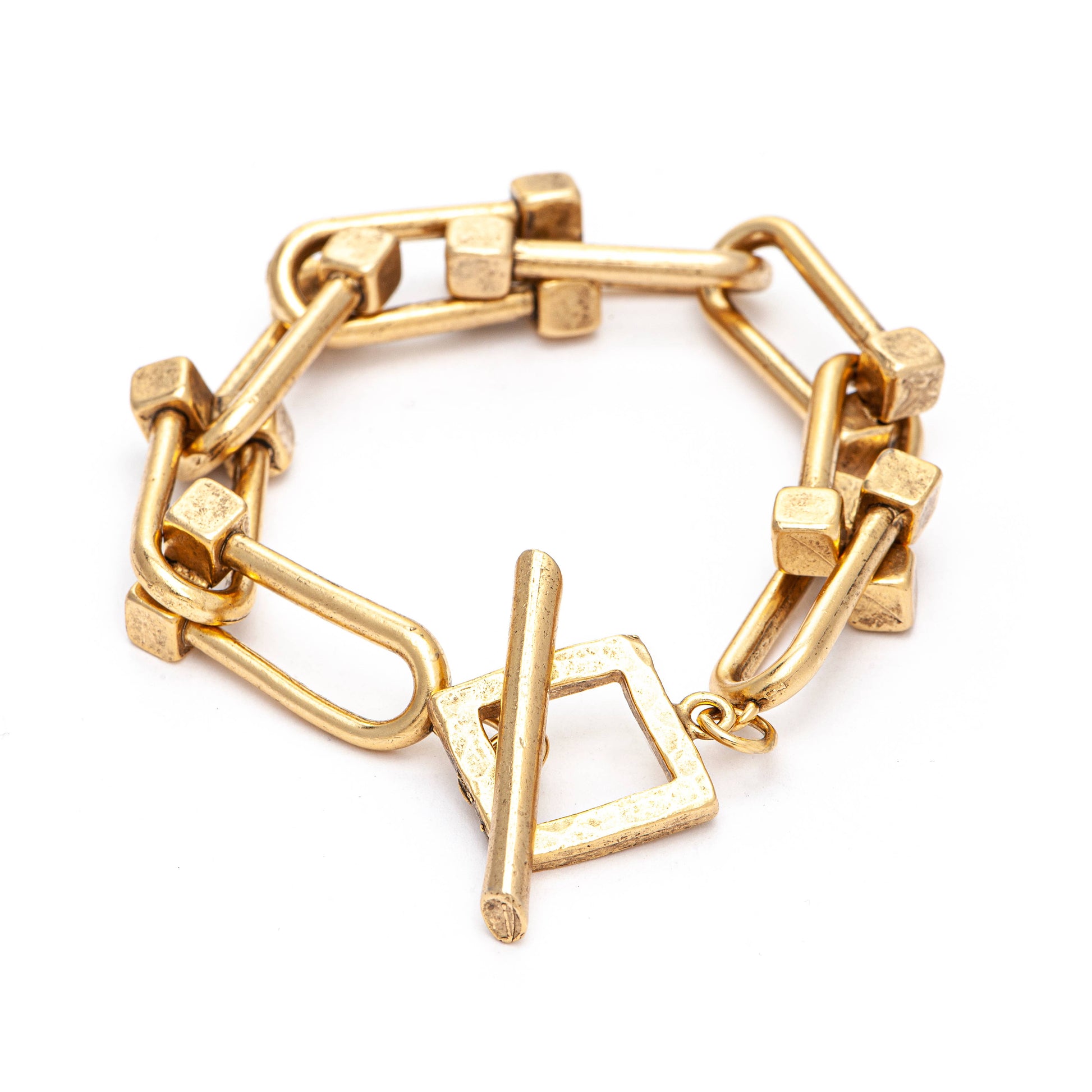 A gold-plated bracelet with a geometric design, including a bar and square toggle, displayed against a white background.