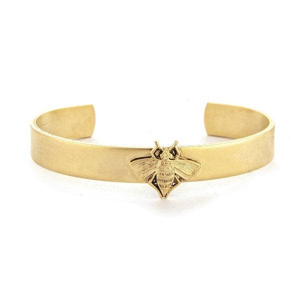 A gold-colored skinny cuff bracelet with a single crafted bee design in the center, displayed against a white background.