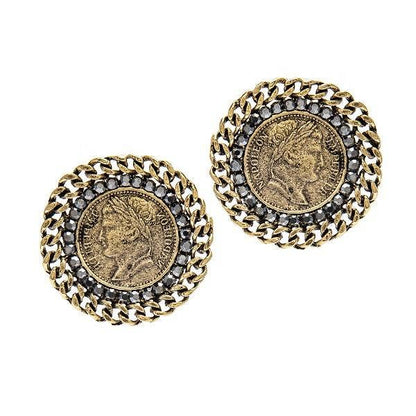 A pair of vintage-inspired earrings with a gold-colored coin design at the center, surrounded by a chain-like pattern and black crystals.