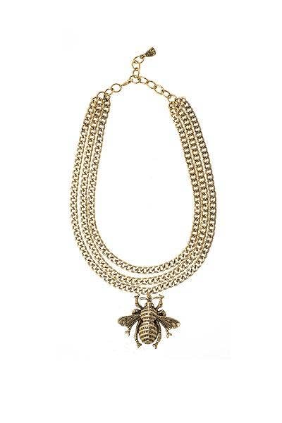 A multi-layered gold chain necklace with a large embellished bee pendant, displayed against a white background.