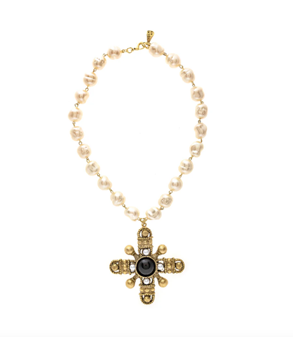 A vintage pearl necklace with a gold-plated brass cross pendant, displayed against a white background.