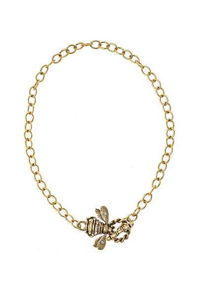 A gold-colored bracelet with a crystal embellished bee charm and a toggle closure.