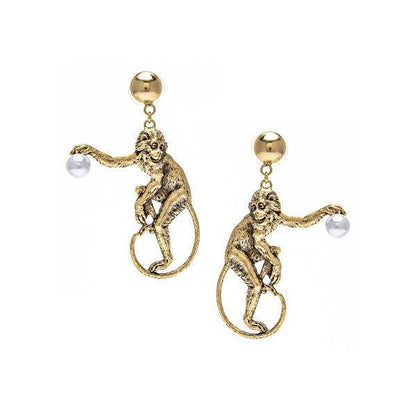 A pair of gold-colored earrings featuring a monkey holding a vintage-inspired pearl
