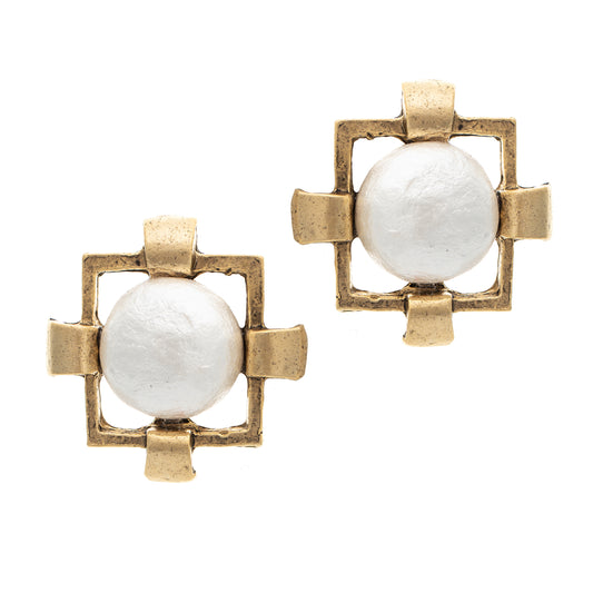 Pair of earrings with gold frames and white central stones on a white background