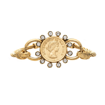 Gold brooch with coin and gemstone design on a white background
