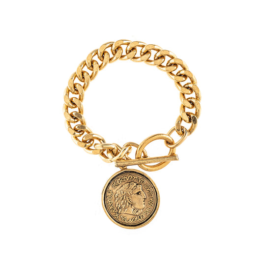 Gold chain bracelet with a coin charm on a white background