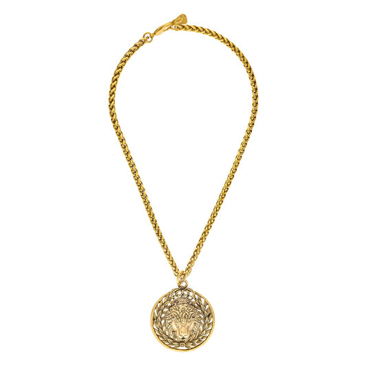 Gold necklace with a round pendant on a white background