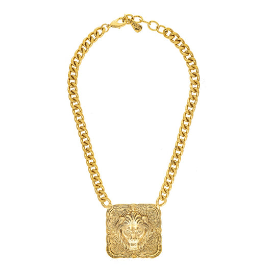 Gold chain necklace with a lion head pendant on a white background