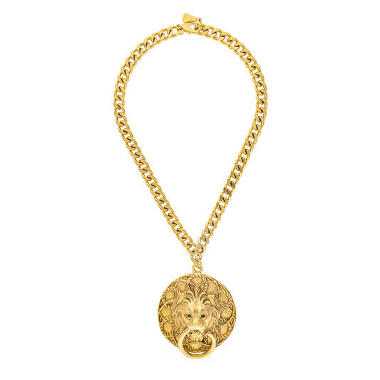 Gold chain necklace with a lion head pendant on a white background