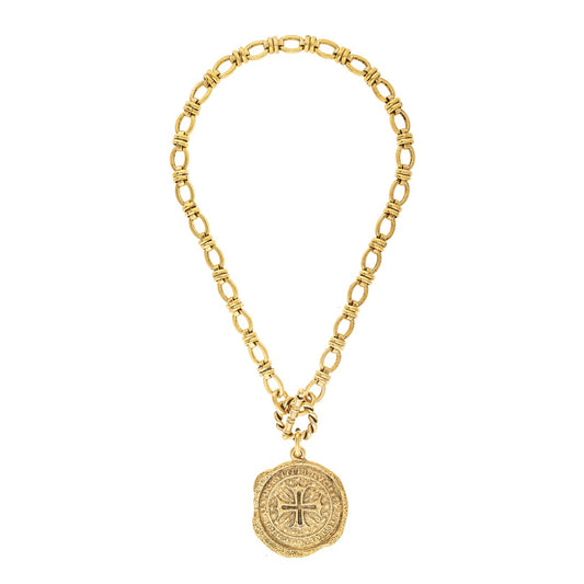 Gold chain necklace with a round pendant on a white background