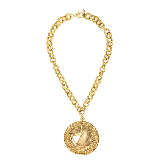 Gold necklace with a round pendant on a white background