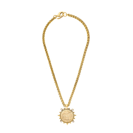 Gold necklace with a circular pendant on a white background