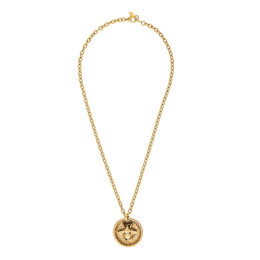 Gold necklace with a circular pendant on a white background