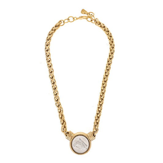 Gold chain necklace with a circular pendant on a white background