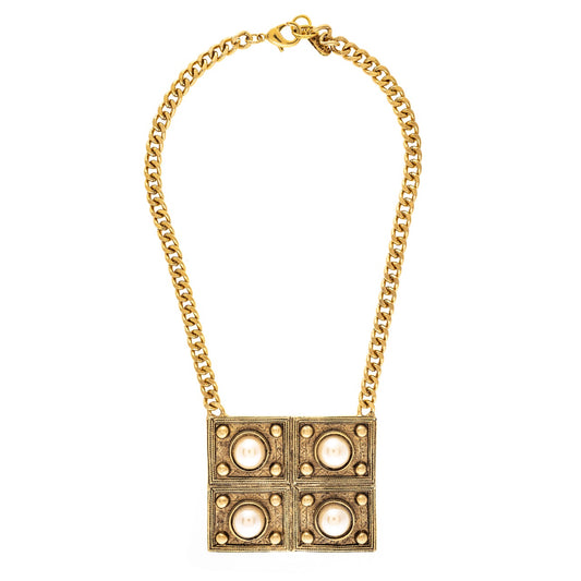 Gold chain necklace with a square pendant on a white background