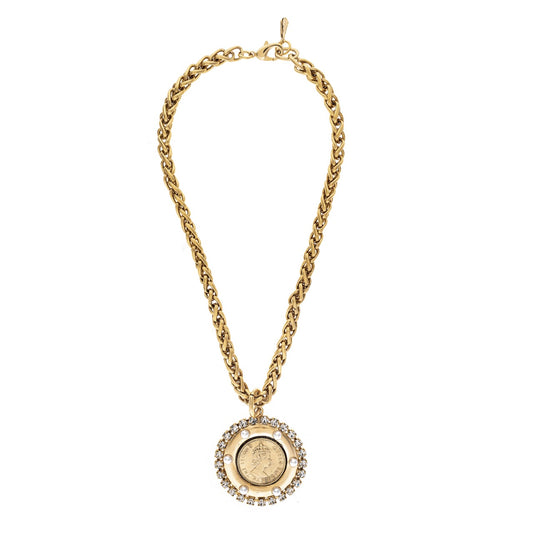 Gold chain necklace with a round pendant on a white background