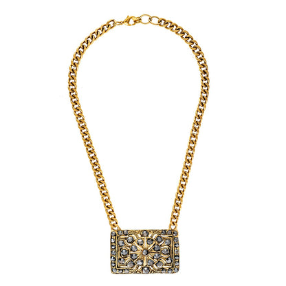 Gold chain necklace with a rectangular pendant on a white background