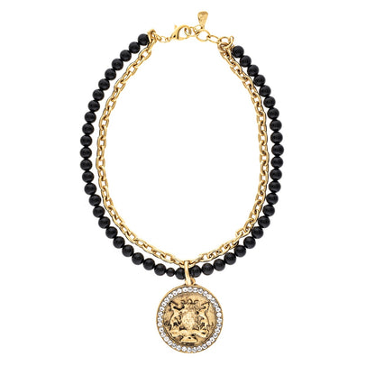 Necklace with black beads and gold chain featuring a round pendant on a white background