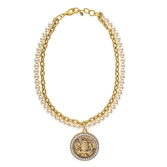 Gold necklace with pearl accents and a decorative pendant on a white background