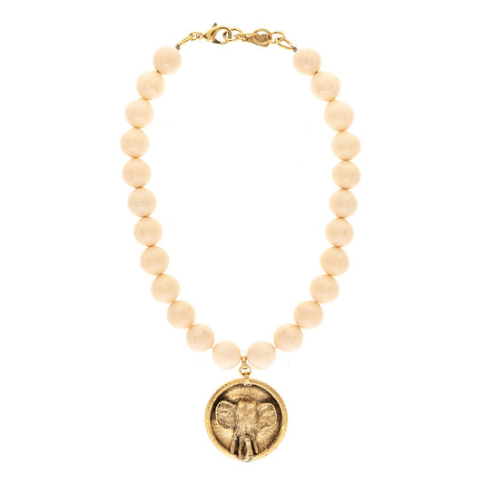 Necklace with beige beads and a gold elephant pendant on a white background