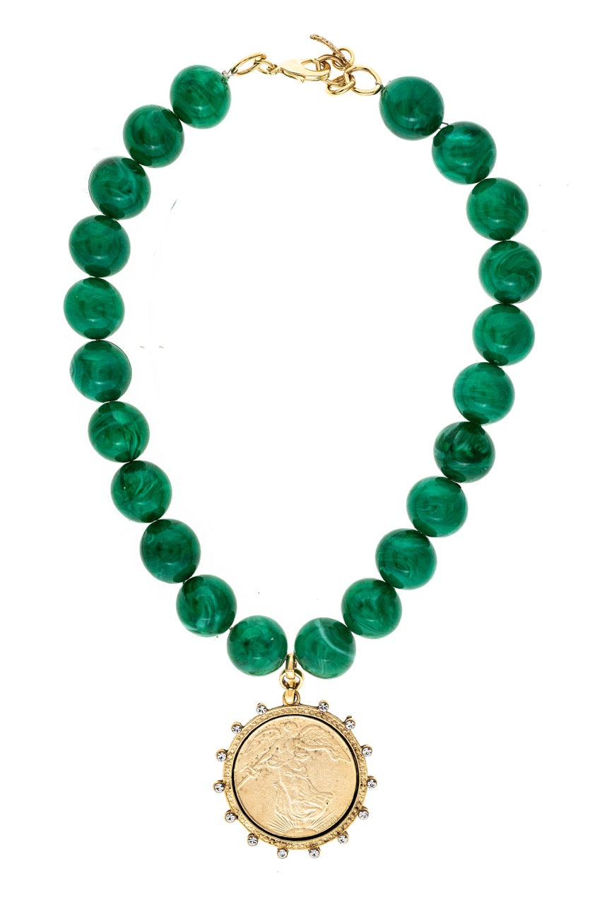 Green beaded necklace with a gold pendant on a white background