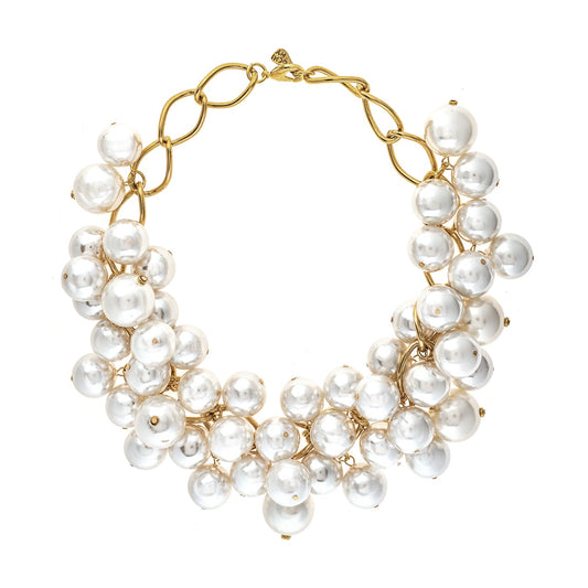 Gold necklace with white pearls on a white background