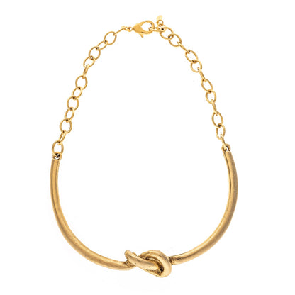 Gold necklace with a knot design on a white background