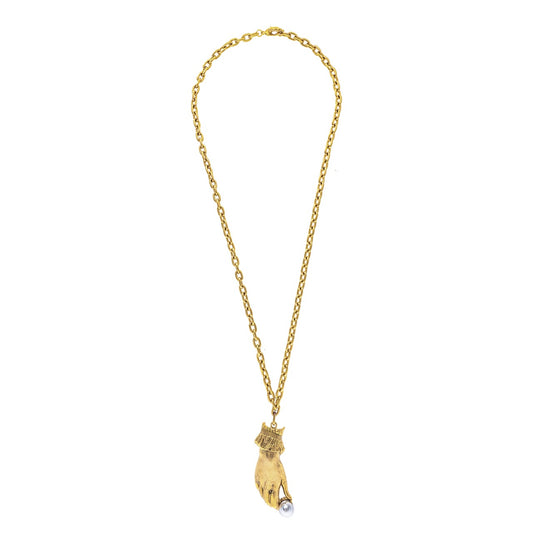 Gold necklace with a hand holding a pearl pendant on a white background