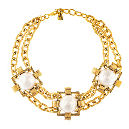 A multi-layered gold-plated necklace with white tri-colored accents, featuring a brass construction.