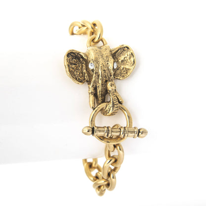 A gold-colored elephant head bracelet charm with a detailed toggle and crystal stones, displayed against a white background.