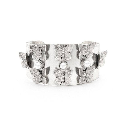 A medium-sized cuff bracelet with a floral pattern, studded with crystals and pearls, and 22K antique gold plating over brass.