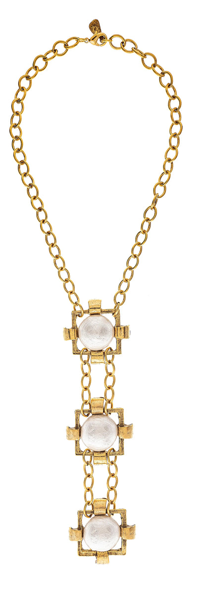 A gold-plated brass necklace with three square white stones aligned vertically on a chain link.